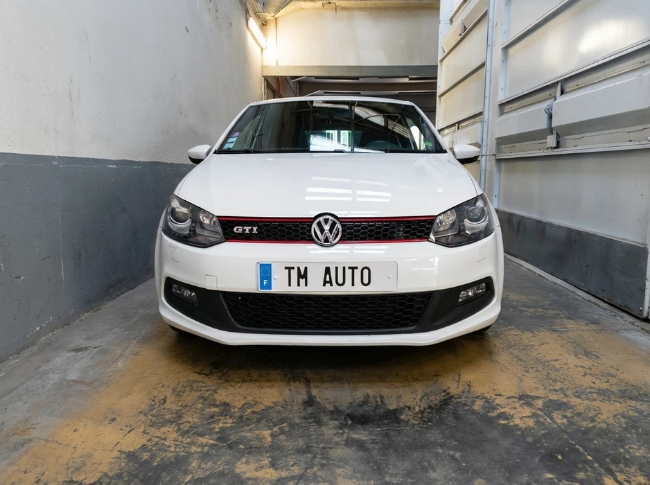 Volkswagen Polo GTI blanche, vue de face, garée dans un couloir de garage étroit
