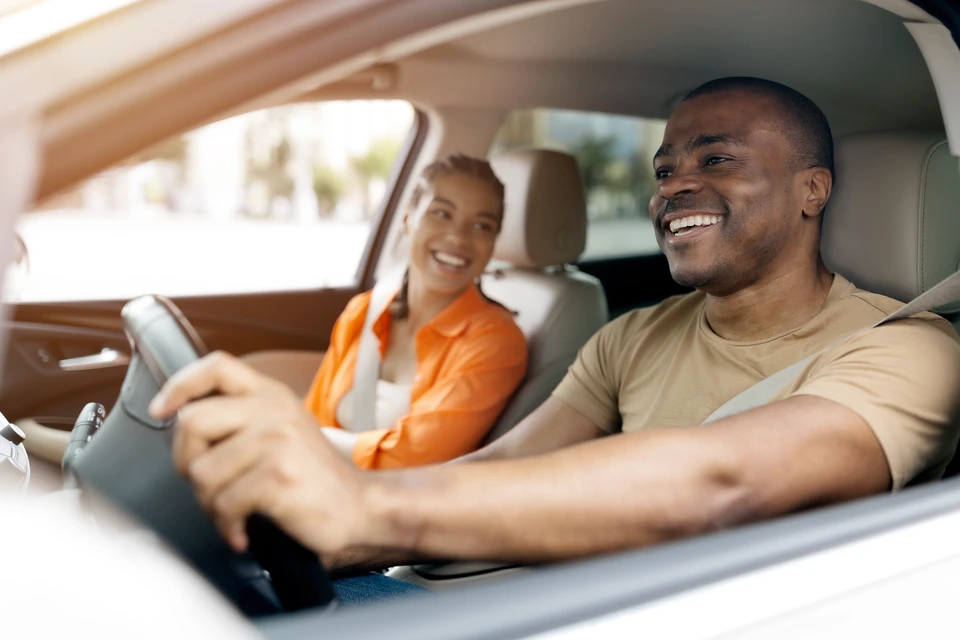 Concession automobile, remise de cl&eacute;s de v&eacute;hicule entre vendeur et jeunes clients souriants