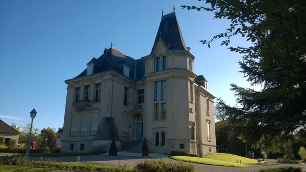 Vue ext&eacute;rieure professionnelle d'une fa&ccedil;ade de garage automobile moderne de petite &agrave; moyenne taille, situ&eacute; en zone urbaine ou p&eacute;riurbaine. Le b&acirc;timent affiche une devanture claire avec des portes de garage fonctionnelles, un parking avec quelques v&eacute;hicules en attente de r&eacute;paration. L'atmosph&egrave;re doit &ecirc;tre professionnelle et accueillante, refl&eacute;tant un garage local &eacute;tabli et de confiance. La photo doit &ecirc;tre prise de jour en conditions d'&eacute;clairage naturel.